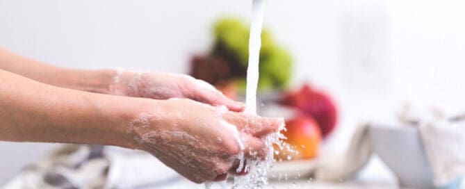 person washing hands in kitchen