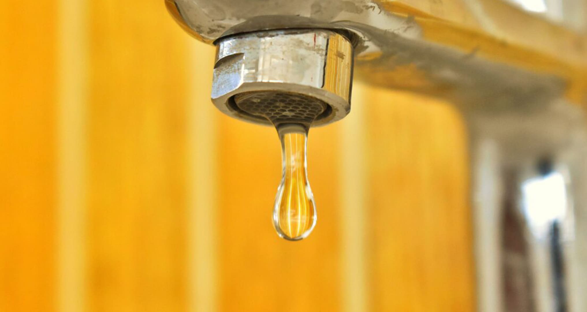 dripping faucet in yellow bathroom