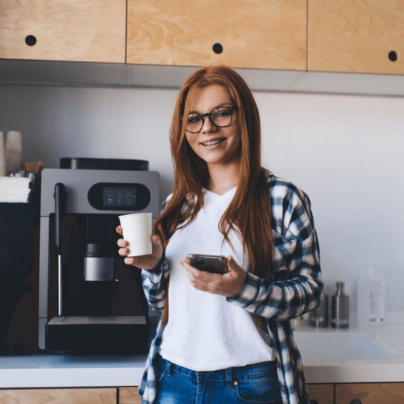 Woman at work getting coffee in breakroom